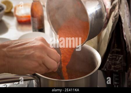 Fare ganache sulla base di peperoni al forno purè. Primo piano. Foto Stock