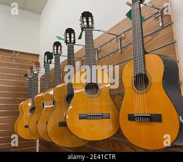 Basso angolo di ripresa di una fila di chitarre elettriche appese in un negozio di musica Foto Stock