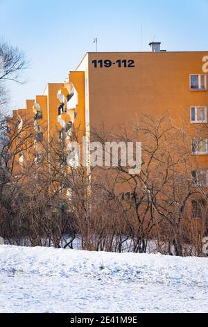 POZNAN, POLONIA - 17 gennaio 2021: Fila di blocchi di appartamenti e alberi in una fredda giornata invernale Foto Stock