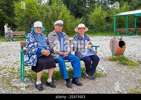 Anziani russi locali che riposano sulla panchina lungo il lago Baikal in estate, Siberia meridionale, Russia Foto Stock