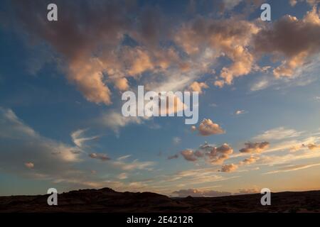 Il sole che tramonta diventa rosa nuvole fluidità basse su Glen Canyons Horseshoe Bend paesaggio nel nord dell'Arizona. Foto Stock