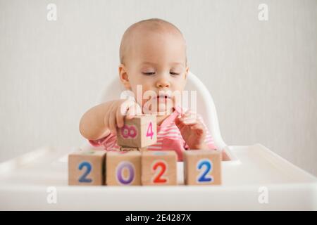 Bambina che gioca con cubetti di legno con numeri luminosi 2022 Foto Stock