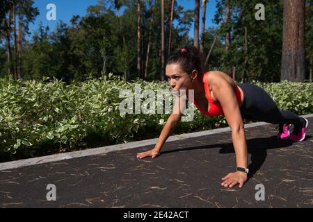 Giovane americanwoman latino sportivo che fa push-up all'aperto. Esercizi di push-up all'aperto Foto Stock