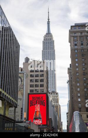 Due icone americane viste nel centro di Manhattan, un cartellone Coca Cola con l'Empire state Building che si erge sullo sfondo. Foto Stock