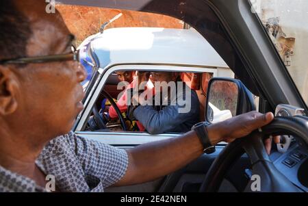 Sendrisoa, Madagascar - 28 aprile 2019: Sconosciuti uomini malgascio in auto che parlano con l'altro conducente del veicolo attraverso il finestrino anteriore circa le condizioni della strada quando pas Foto Stock