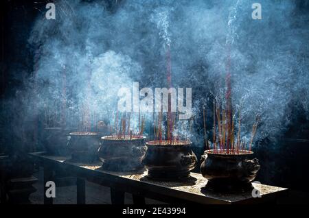 Fumare bobine coniche di incenso e urne al tempio di Chua Thien Hau a Cho Lon, ho Chi Minh City, Vietnam. Foto Stock