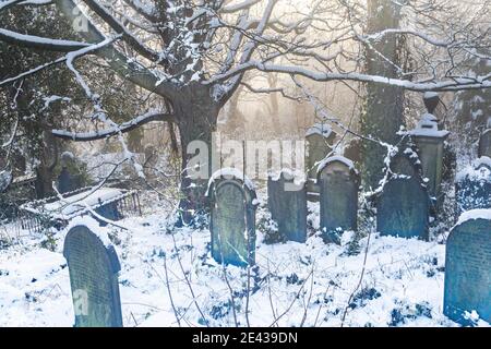 Un cimitero in inverno. Chiesa di San Giovanni d'Inghilterra, Baildon, Yorkshire, Inghilterra. Foto Stock