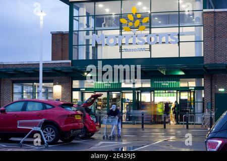 I clienti in maschera di faccia caricano i loro acquisti nel bagagliaio dell'automobile all'esterno del supermercato morrisons aperto per affari durante la covid-19 Foto Stock