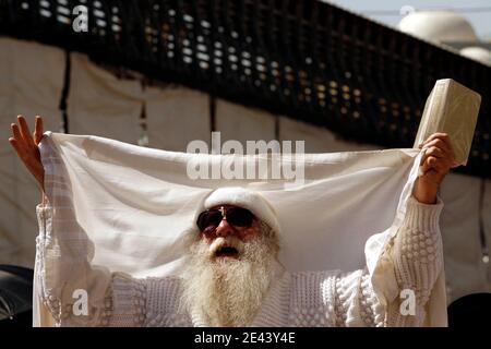 Un uomo ebreo diffonde la sua preghiera mentre si allontana dal Muro Occidentale, come è consuetudine durante la benedizione sacerdotale, o Birkat Kohanim, eseguita durante l'alta festa ebraica di Pasqua a Gerusalemme, Israele, il 12 aprile 2009. Migliaia di ebrei ultra-ortodossi partecipano alla preghiera speciale per le persone chiamate Cohen, che sono i discendenti degli antichi sommi sacerdoti dei templi. La Benedizione sacerdotale si svolge più volte all'anno, in particolare nelle feste di Pasqua, Sukkot e Shavuot. Foto di Olivier Fitoussi /ABACAPRESS.COM Foto Stock