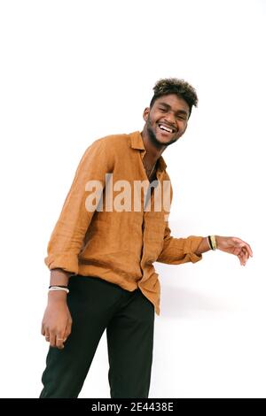 Bel ragazzo nero hipster con i capelli ricci vestito in una camicia bianca casual che guarda la macchina fotografica Foto Stock