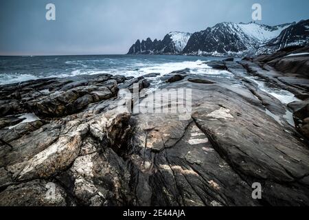 Magnifico scenario di mare e montagne sotto il cielo nuvoloso grigio In inverno in Norvegia Foto Stock