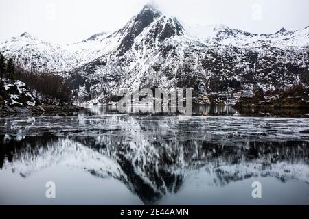 Magnifico scenario di mare e montagne sotto il cielo nuvoloso grigio In inverno in Norvegia Foto Stock