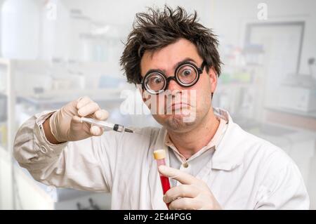 Giovane scienziato pazzo che esegue esperimenti in laboratorio Foto Stock