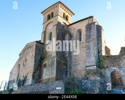 Saint Hilaire Aude France 01/18/21.esterno di un'abbazia francese. Campana quadrata con pareti in pietra e torre dell'orologio. Finestre ad arco. Contrafforti di supporto. Foto Stock