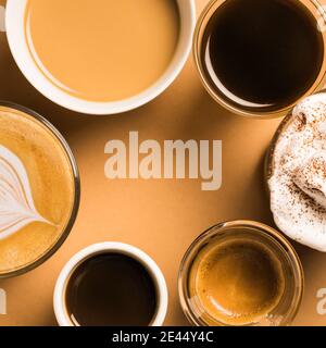 Set di diversi tipi classici di bevande aromatiche al caffè serviti in tazze di varie misure disposte su superficie beige Foto Stock