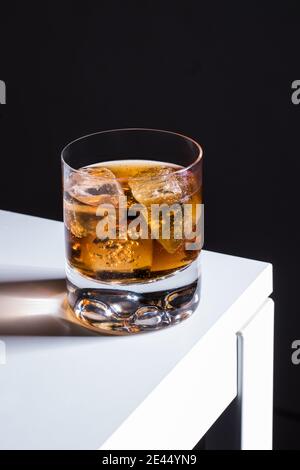 Alcol cocktail vecchio stile con whisky e amaretti di ghiaccio guarnito cubetto servito in vetro Foto Stock