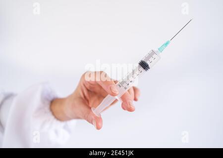 Vaccino non riconoscibile per mano femminile tagliato da coronavirus in siringa in sala medica dell'ospedale Foto Stock