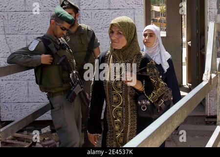 "Le donne palestinesi passano davanti alle guardie di polizia di frontiera israeliane mentre attraversano un punto di controllo nel centro della città di Hebron, in Cisgiordania, il 18 maggio; 2009 nel corso di una visita di una delegazione di parlamentari israeliani ultrationalisti che protestano contro la promozione del primo ministro israeliano Benjamin Netanyahu dell'allentamento delle restrizioni ai palestinesi. Netanyahu avrà il primo incontro faccia a faccia con il presidente Barack Obama tra le divisioni sul pacemaking del Medio Oriente e le ambizioni nucleari dell'Iran. Il Premier falco, che vuole un approccio "fresco" al conflitto israelo-palestinese, si svelerà nella Casa Bianca Foto Stock