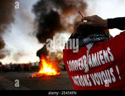 Goodyear Tire & Rubber Workers dello stabilimento della Francia settentrionale di Dunlop ad Amiens si trovano di fronte a un blocco fatto con pneumatici brucianti per bloccare l'accesso alla loro fabbrica durante una dimostrazione presso il sito, il primo giorno di azioni settimanali per protestare contro ag Foto Stock
