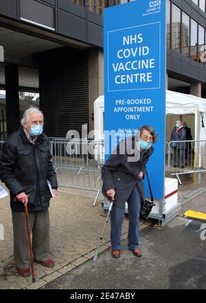 Un'ex infermiera anziana con il marito che indossa maschere facciali lascia il centro di vaccinazione dopo aver ricevuto la prima dose del vaccino Astra Zeneca Oxford. Un flusso costante di persone anziane con appuntamenti prenotati presso il nuovo centro di vaccinazione Covid-19 presso l'Olympic Office Centre, vicino allo stadio di Wembley di Londra. Si tratta di uno dei 10 nuovi centri di vaccinazione su larga scala aperti questa settimana, per unirsi ai sette già in uso in tutto il paese. Finora 4.9 milioni di persone in tutto il Regno Unito hanno ricevuto la prima dose di vaccino e il governo intende che tale numero salirà a 15 milioni entro il 15 febbraio. Foto Stock