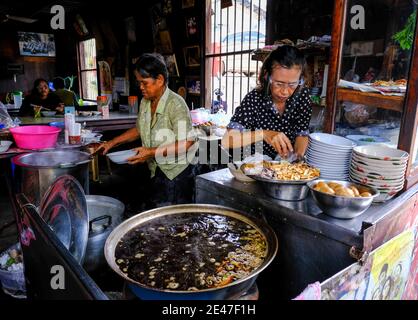 Le Signore cucinano cibo tailandese in un ristorante nel centro storico di Chanthaburi, Thailandia Foto Stock