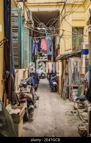 Scena di strada da un vicolo stretto nel vecchio quartiere di Hanoi. Le strade e le corporazioni del quartiere vecchio sono una delle principali attrazioni turistiche Foto Stock