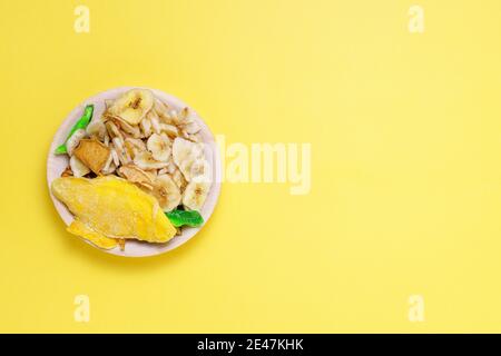 Assortimento di frutta secca e cruda su sfondo giallo, concetto di cibo sano Foto Stock