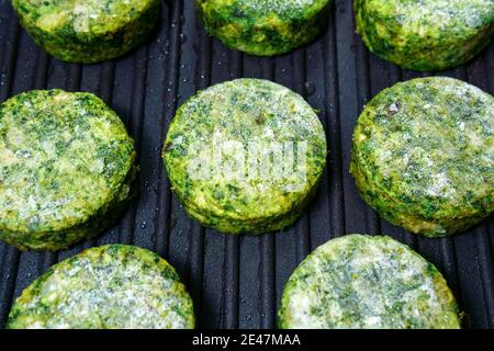 sulla griglia vengono preparate delle cutlet vegetariane di broccoli. primo piano fuoco selettivo Foto Stock