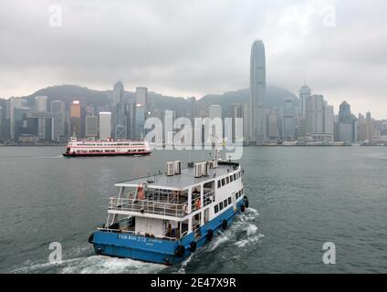 In una mattinata grigia fredda un'altra stella del traghetto porta i passeggeri e i pendolari sopra Hong Kong da Kowloon. Foto Stock