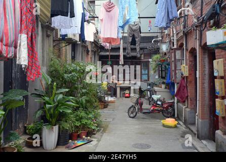 Scena di strada in una vecchia comunità di Shanghai, queste case a maglia stretta sono probabilmente da demolire 2021. I quartieri scompariranno per gli alloggi moderni. Foto Stock