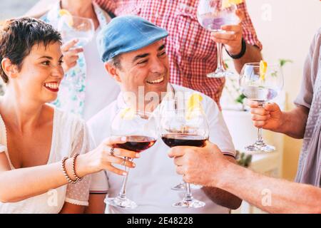 Un gruppo di allegri amici caucasici si divertono e festeggiano insieme con vino rosso e cocktail bicchieri - la gente celebra e. godetevi l'amicizia Foto Stock