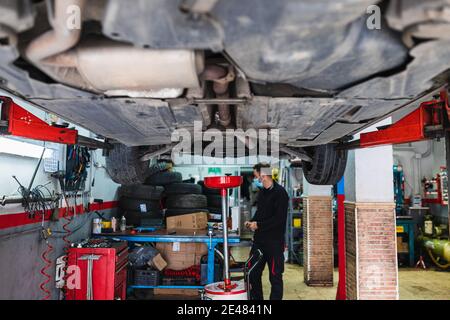 Meccanico sotto un'auto. Concetto di meccanica dell'automobile Foto Stock