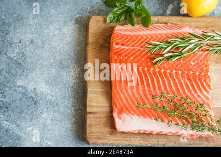 Salmone. Filetto di salmone fresco crudo con ingredienti da cucina, erbe e limone. Primo piano. Cibo sano, dieta o concetto di cucina Foto Stock