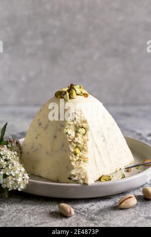 Paskha e kulich con pistacchi. Tradizionale russo ortodosso Quark di Pasqua Dessert caglid. Pasqua cibo sfondo. Torta di formaggio cottage tradizionale Foto Stock
