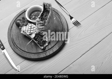 Carne tritata avvolta con pane di lavasino su sfondo di legno giallo. Pane piatto con ripieno di maiale o pollo e salsa di peperoncino rosso. Concetto di fast food. Burrito o tortilla serviti in ristorante o caffè. Foto Stock