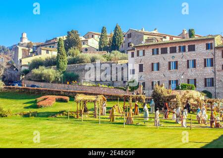 Assisi, Umbria - 12 30 2019: Atmosfera natalizia, Crippa sull'erba e città vecchia e collina con albero sullo sfondo Foto Stock