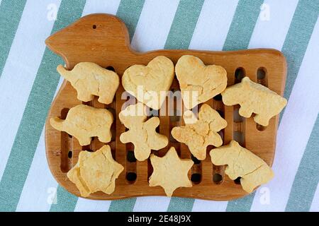 Biscotti appena sfornati fatti in casa di forma bella del burro che si stanno raffreddando sopra Breadboard in legno Foto Stock