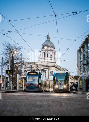 Nottingham UK centro città shopping Trams council house illuminato con tram parcheggiato di fronte illuminato ai lam di strada notturna e cavi treno in attesa Foto Stock