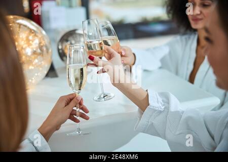 Tre migliori amiche che tostano con champagne Foto Stock