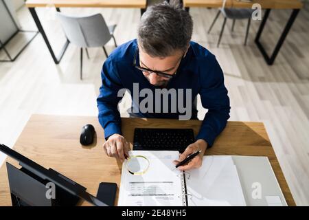 Rilevatore di frodi tramite lente di ingrandimento o lente di ingrandimento Foto Stock