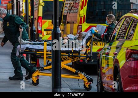Londra, Regno Unito. 22 gennaio 2021. Londra, Regno Unito. 22 Jan 2021. Una medica in un respiratore e DPI completi assiste ad un paziente portato in da una combinazione di Air Ambulance, il London Ambulance Service e la polizia - le ambulanze arrivano al reparto di incidente e emergenza per lasciare i pazienti al Royal London Hospital di Whitechapel. Londra è in nazionale Lockdown 3 e la pressione sui letti nel NHS rimane alta. Credit: Guy Bell/Alamy Live News Foto Stock