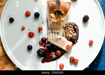 Vista alta su una porzione di cheesecake fatta in casa e sulle bacche. Primo piano Foto Stock