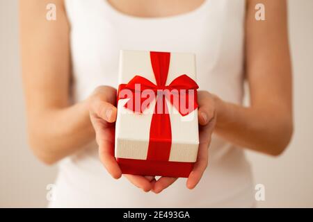 Le mani della donna tengono presente con nastro rosso da vicino Foto Stock