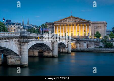 Pont de la Concorde sulla Senna con l'edificio illuminato Assemblee Nationale Beyond, Parigi, Francia Foto Stock