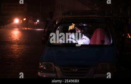 MUMBAI, INDIA - 17 dicembre 2020 : un tassista sikh seduto all'interno di un taxi nella notte buia a Mumbai Foto Stock