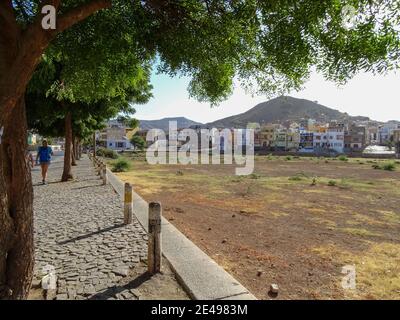 Capo Verde, tour a piedi dell'isola di Sao Vicente, escursionista in un paesaggio arido con alcune case. Foto Stock