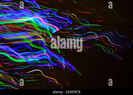 Astratto effetto multicolore sfocato di energici fili orizzontali creati fotografando luci a LED all'aperto di notte. Foto Stock