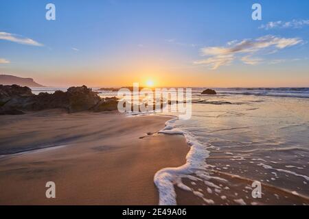 Spiaggia con rocce a bassa marea, tramonto, da Playa del Castillo, Playa del Algibe de la Cueva, Fuerteventura, Isole Canarie, Spagna Foto Stock