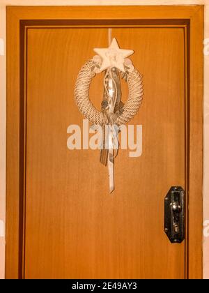 Corona di Natale appesa su una porta di legno. Foto Stock