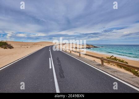 Strada accanto alla spiaggia di Playa del Moro, Fuerteventura, Isole Canarie, Spagna Foto Stock